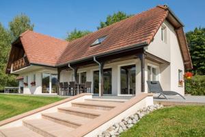 ein Haus mit Wintergarten mit Dach in der Unterkunft Villa Le Chant des Sapins - Tennis, Pool, Golf in Le Saulcy