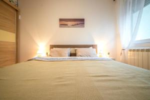 a bedroom with a large bed with two lamps at Katarina Premium Apartments in Pirot