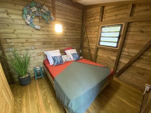 a bedroom with a bed in a log cabin at Kaz ananas, spa privatif ,plage du Helleux in Sainte-Anne