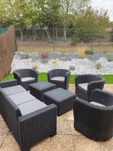 a group of wicker chairs sitting on a patio at Agréable maison de ville avec jardin + garage. in Coulaines