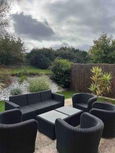 a patio with a couch and chairs and a table at Agréable maison de ville avec jardin + garage. in Coulaines