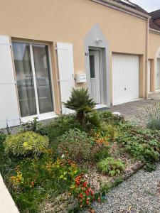a garden in front of a house with flowers at Agréable maison de ville avec jardin + garage. in Coulaines
