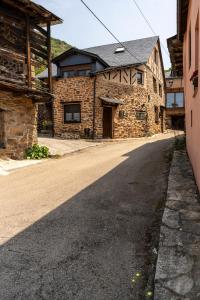an empty road in front of a stone building at Casa de turismo rural Sardom2 in Bembibre