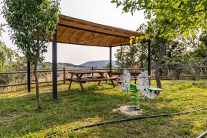 a picnic shelter with a picnic table and a bench at Casa de turismo rural Sardom2 in Bembibre