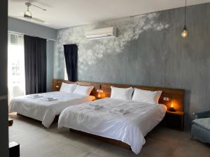a bedroom with two beds with white sheets and a wall at An Blue House in Dazhou +32 photos