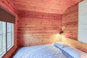 ein hölzernes Zimmer mit einem Bett in der Ecke in der Unterkunft Pinetree Cottages Cozy log cabin in Kalanti