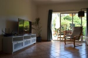 a living room with a flat screen tv on a cabinet at casa pipoca in Lagos