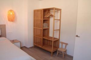 a wooden book shelf in a room with a bed at Ca Lanosa in Alicante