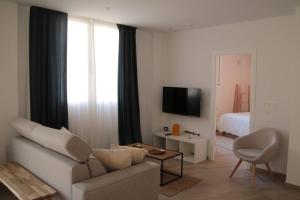 a living room with a couch and a chair and a television at Ca Lanosa in Alicante