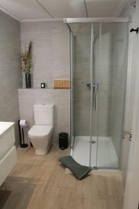 a bathroom with a toilet and a glass shower at Ca Lanosa in Alicante +10 photos