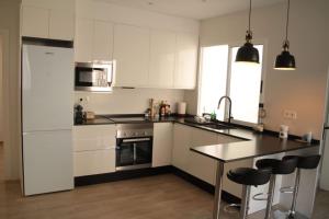 a kitchen with white cabinets and a black counter top at Ca Lanosa in Alicante