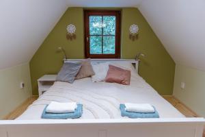 a bedroom with a large white bed with a window at PAMPUSKA Apartman in Gyomaendrőd