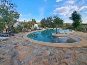 una piscina con una pasarela de piedra alrededor en Sierra hornachos, en Hornachos