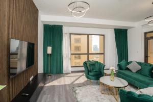 een woonkamer met groene meubels en een televisie bij Route 66 Beach Hostel in Dubai