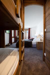 a bedroom with two beds and a large window at La Maison Les Peupliers in Courchevel