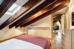 1 dormitorio con 1 cama en una habitación con techos de madera en Victor Apartments Plaza España, en Madrid