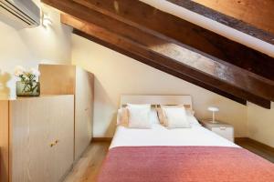 a bedroom with a large bed with a wooden ceiling at Victor Apartments Plaza España in Madrid