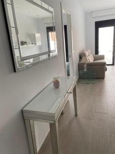 a living room with a table and a mirror at New villa, 2 bedrooms private heated pool sleeps up to 6 in Pilar de la Horadada