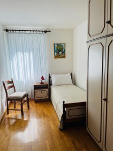 a bedroom with a bed and a chair and a window at Appartamento Al Lago in Chiesa