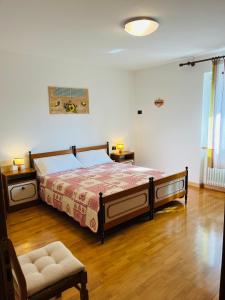 a bedroom with a large bed and a chair at Appartamento Al Lago in Chiesa