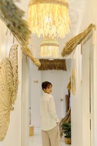 a woman standing in a hallway under a chandelier at Pallet Homes - Landheights Tropics in Iloilo City