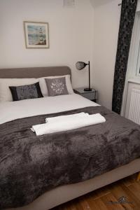 a bedroom with a bed with two white towels on it at Cosy home with private parking in Bloxwich