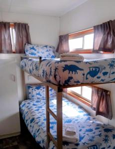 two bunk beds in a small room with a window at Rock’s Retreat - cabin 1 (seal) in Carpenter Rocks