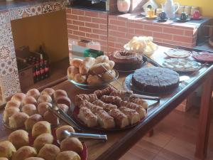 uma mesa com diferentes tipos de bolos e pastelarias em Casa do Osorio em Viscode de Mauá