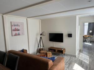 Zaandam Cottage Centre - Zaanse Schans Amsterdam في زاندام: غرفة معيشة مع أريكة وتلفزيون بشاشة مسطحة