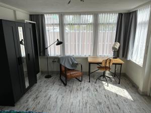 a room with a desk and a lamp and chairs at Zaandam Cottage Centre - Zaanse Schans Amsterdam in Zaandam