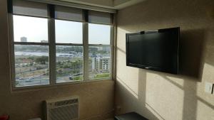 サンファンにあるLouis Vistas de San Juanの薄型テレビ、窓2つが備わる客室です。