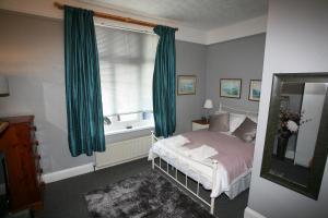 a bedroom with a bed and a window with green curtains at Flat 1 in Teignmouth