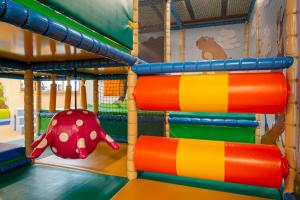 un parque infantil con toboganes coloridos y un juguete para elefantes en Montela Hotel & Resort - Montela Pavillon en Saas-Grund