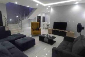 a living room with a couch and a television at Lekki holiday shortlet in Lekki