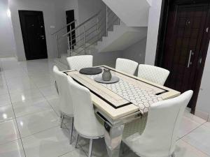 a dining room with a table and white chairs at Lekki holiday shortlet in Lekki