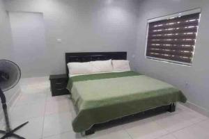 a bedroom with a green bed and a window at Lekki holiday shortlet in Lekki