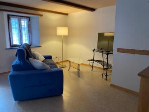 a living room with a blue couch and a tv at Casa nonna Domenica in Brontallo