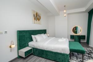 een slaapkamer met een groot bed met een groen hoofdeinde bij Route 66 Beach Hostel in Dubai