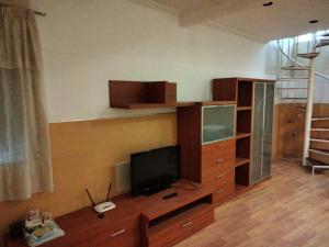 a living room with a tv on a wooden entertainment center at CASA ANTONIO in Murcia
