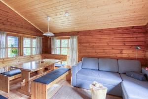 a living room with a couch and a table at Pinetree Cottages Blue Cabin in Pyhäranta