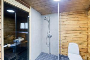 a bathroom with a shower stall and a toilet at Pinetree Cottages Blue Cabin in Pyhäranta