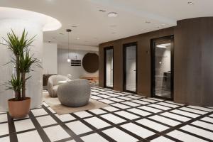 a lobby with chairs and plants on a tiled floor at Noli Katajanokka II in Helsinki