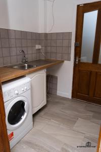 a kitchen with a washing machine and a sink at Cosy home with private parking in Bloxwich