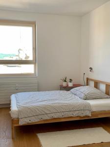 a white bedroom with a bed and a window at host.salzburg in Salzburg