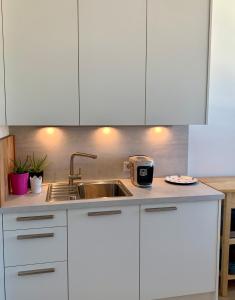 a kitchen with white cabinets and a sink at host.salzburg in Salzburg