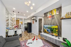 a living room with a couch and a flat screen tv at Cozy 2 Bedroom Condo in Masteri Thao Dien, Fully Furnished With Full Amenities in Ho Chi Minh City