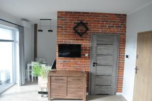 ein Wohnzimmer mit einer Ziegelwand und einer Tür in der Unterkunft JM Apartament in Ustronie Morskie