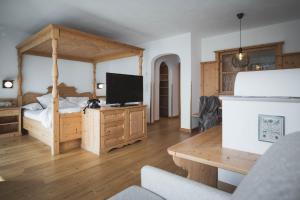 um quarto com uma cama e uma televisão em Kronplatz-Resort Berghotel Zirm em Valdaora