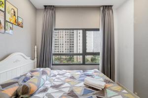 a bedroom with a bed and a large window at Cozy 2 Bedroom Condo in Masteri Thao Dien, Fully Furnished With Full Amenities in Ho Chi Minh City