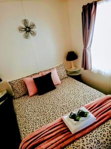 a bedroom with a cheetah print bed with a tray on it at Rock’s Retreat - cabin 1 (seal) in Carpenter Rocks